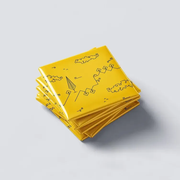 A stack of folded yellow Shiraz Collection totes, the line drawing printed across the top fold